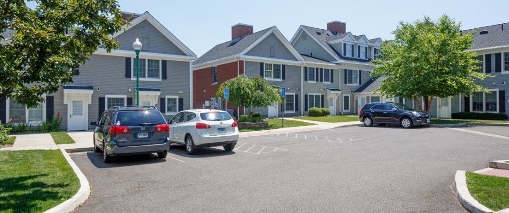 A dedicated parking area features standard and handicap parking spaces. Wheelchair accessible sidewalks line the area.