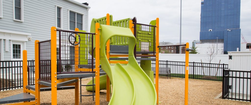 The brightly colored playscape has slides, ladders, stairs and more for children to play on, and a park bench for parents.