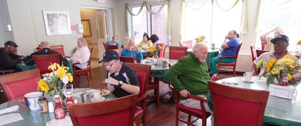 The light-filled dining area is full of residents enjoying their meals and each other's company.
