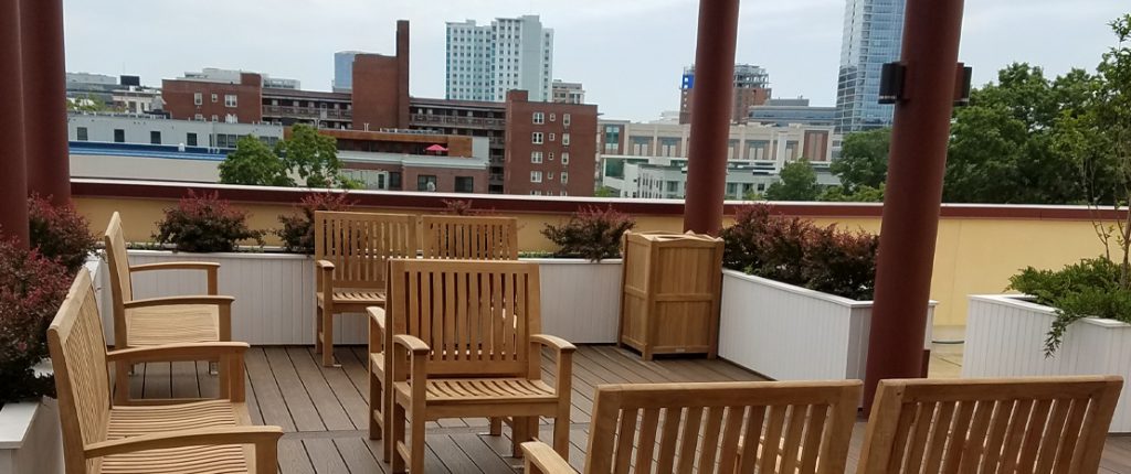 Summer Place's inviting rooftop patio features seating arranged to spark conversation, surrounded by boxed gardens.